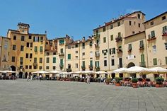 several buildings with umbrellas and tables in front of them