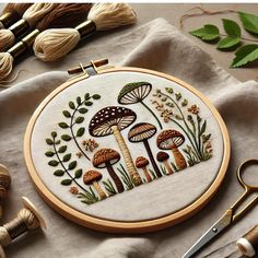 an embroidery project with mushrooms and leaves on it