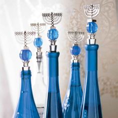 three blue glass bottles with candlesticks in them