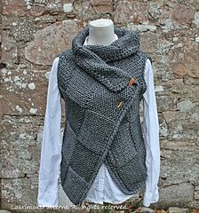 a knitted vest on display in front of a stone wall