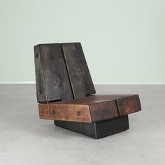 a wooden chair sitting on top of a cement floor next to a wall in an empty room