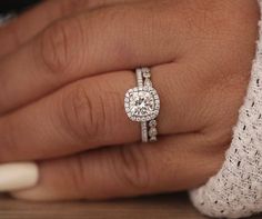 a close up of a person's hand with a diamond ring on their finger