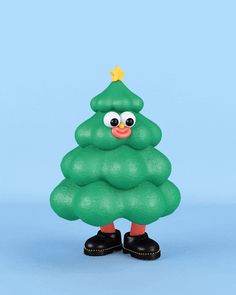 a green plastic christmas tree with googly eyes and black rubber shoes, on a blue background