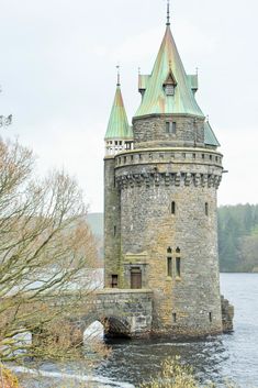 an old stone tower sitting on top of a river