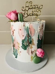 a birthday cake decorated with cactus and flowers