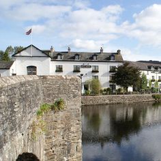 a river running through a small town next to a tall white building with lots of windows