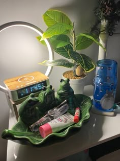 there is a clock, plant and other items on the table in front of it