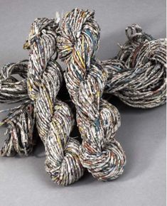 several ropes are stacked together on a gray surface and one is white, the other has multicolored stripes