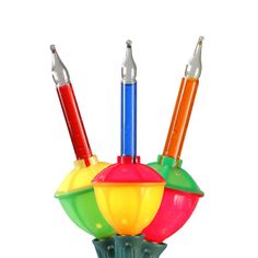 three different colored lights on top of each other in a glass vase with two pens sticking out of it