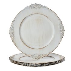 a set of four white dinner plates with gold trimmings on the rim and sides