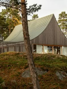 a wooden house on top of a hill surrounded by trees