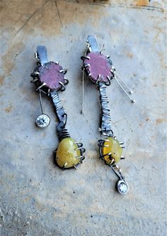 Rustic, arty, one-of-a-kind, mismatched artisan post earrings featuring Raw Ruby slices and Yellow Opal rose cuts with dendritic inclusions set in oxidized Sterling prongs. Swinging bezel-set 7mm and 4mm AAAAA diamond brilliant cut Cubic Zirconia add sparkly pizzaz. Additional wire wrapping and slender flame-balled dangles further embellish these special earrings. Lots of movement, unique design elements, raw gemstones, rich colors, and bright sparkle are found here. These are post/stud earrings Special Earrings, Rough Gemstone Jewelry, Mod Earrings, Earring Hanger, Bold Statement Jewelry, Creative Jewelry Photography, Raw Ruby, Raw Stone Jewelry, Raw Gemstone Jewelry