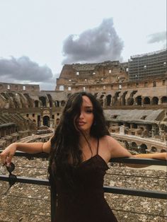 a woman standing in front of the colossion with her hand on her hip