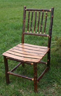 a wooden chair sitting on top of a lush green field