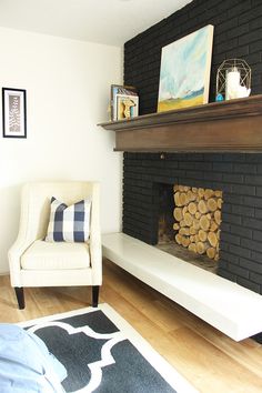 a white chair sitting in front of a fire place next to a black brick wall