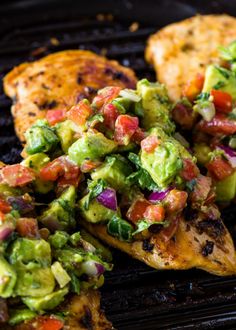 grilled chicken with guacamole and tomato salsa on the side, ready to be eaten