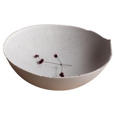 a white bowl with some flowers in it