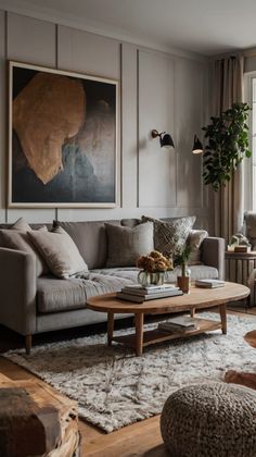 a living room filled with furniture and a large painting on the wall above it's windows