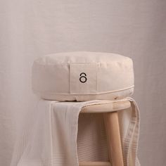 a chair with a white blanket on top of it and a wooden stool next to it