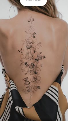 the back of a woman's neck with flowers on it