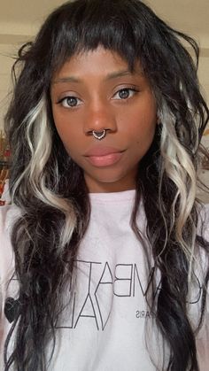 a woman with long black hair and piercing on her nose wearing a t - shirt