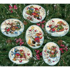 the cover of cross stitch book, featuring six small white plates with designs on them