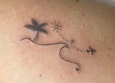 a woman's back with a small palm tree and airplane tattoo on her left shoulder