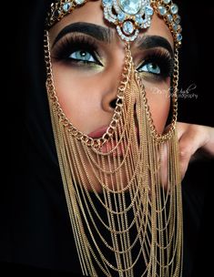 a close up of a woman with chains on her face and eye make - up