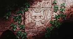 a brick wall with vines growing on it and a drawing of a cat in the middle