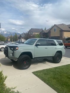 a light blue toyota truck parked in front of a house