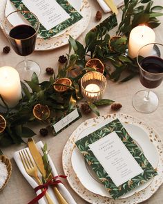 the table is set with place settings, candles, and napkins for christmas dinner