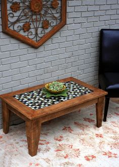 a coffee table with a checkerboard pattern on it in front of a brick wall