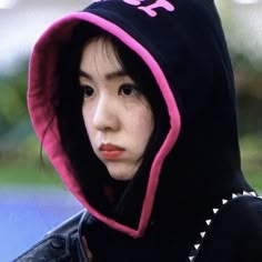 a young woman wearing a black and pink hoodie