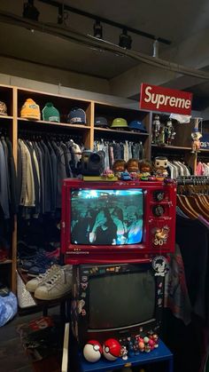 a room filled with lots of different types of clothes and hats on display in front of a television