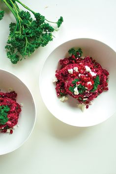 two white bowls filled with food on top of a table