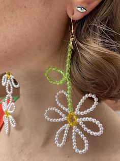 a close up of a person wearing earrings with flowers on it's ear wires