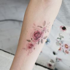 a woman's arm with a rose tattoo on the left side of her arm