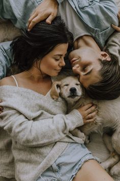 a man and woman laying on the ground with their dog