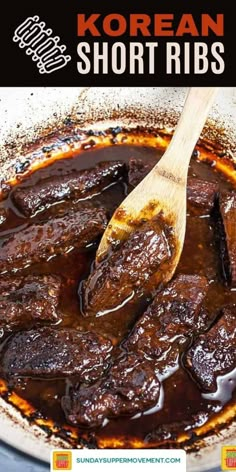 the korean short ribs are being cooked in a skillet with a wooden spatula