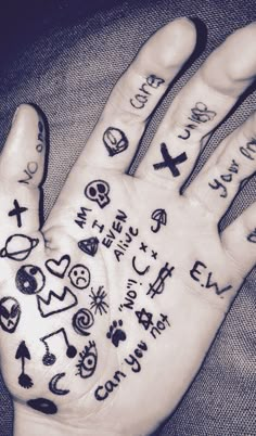 a person's hand with tattoos on it and writing all over the palm area