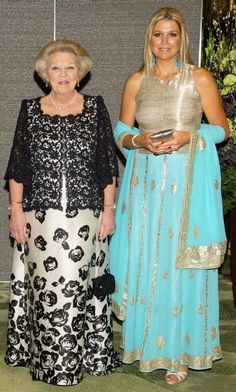 two women standing next to each other in dresses