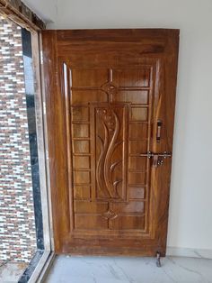 a wooden door with decorative carvings on the front and side panels, in an empty room