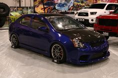 several different colored cars are on display in a showroom