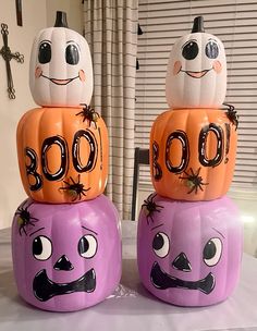 three pumpkins with faces on them sitting on top of each other in front of a window