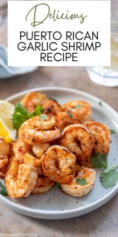 a white plate topped with shrimp next to lemon wedges