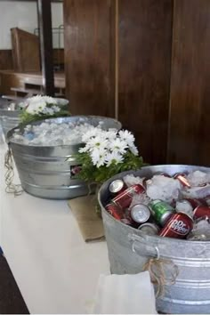 two buckets filled with ice and flowers on a table