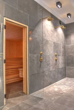 an indoor sauna is shown with glass doors and light fixtures on the side wall