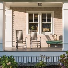 two rocking chairs on the front porch of a house