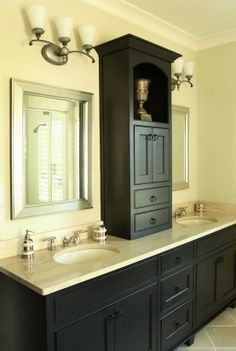 a bathroom with double sinks and black cabinets