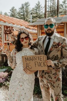 a man and woman standing next to each other holding a sign that says married as fock